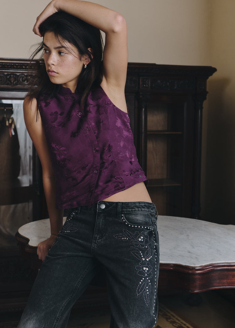 Jeans de tiro bajo en negro con diseño floral de tachas en el lateral