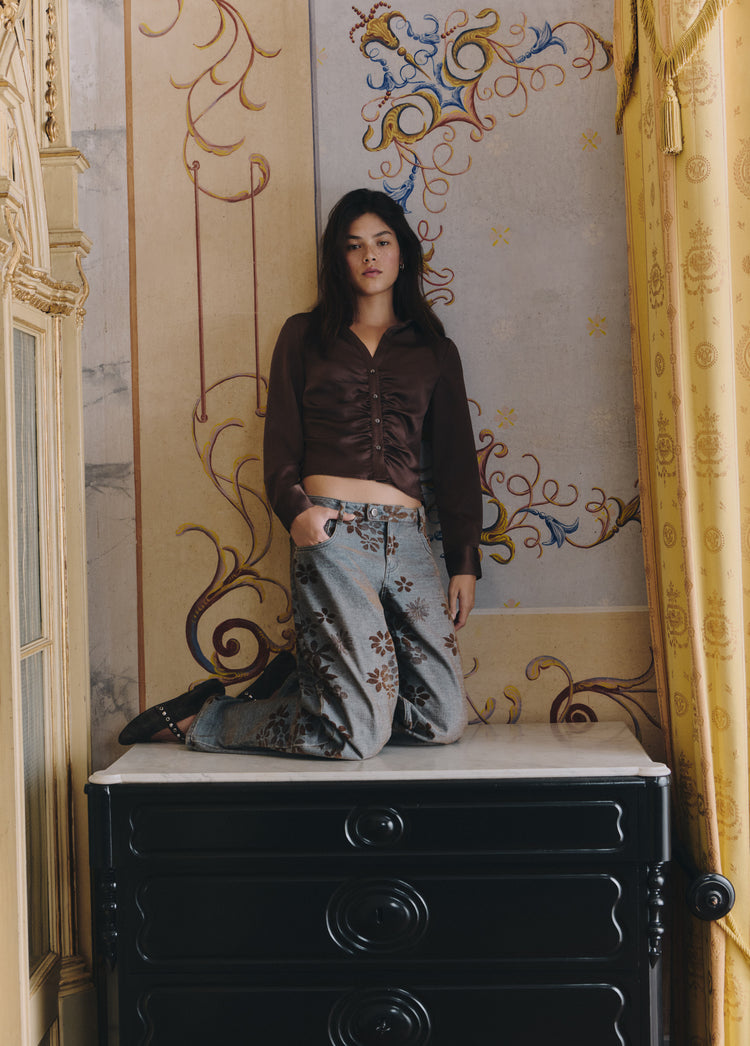Jeans jacquard flores en azul medio sobre modelo con la mano en el bolsillo