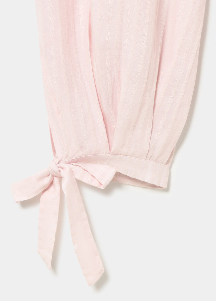 Detalle del pantalón largo bombacho rosa con lazo en la pernera