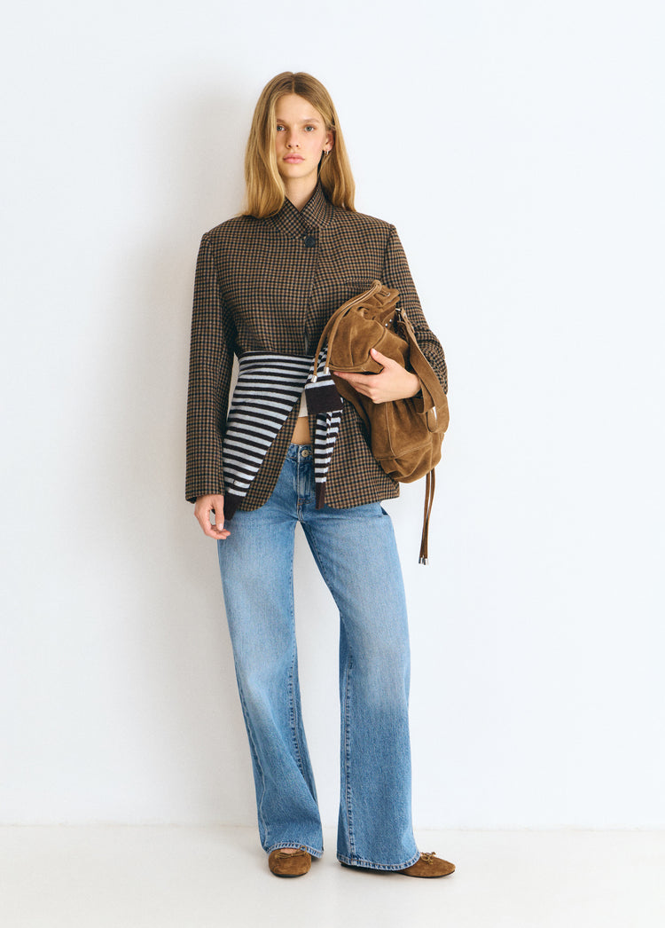 Bolso shopper fruncido de color camel lucido sobre modelo con su correa colgando
