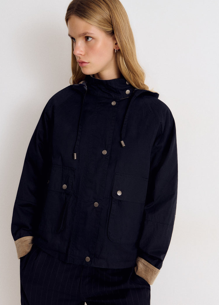 Chaqueta azul marino con capucha y botones metálicos vista de frente