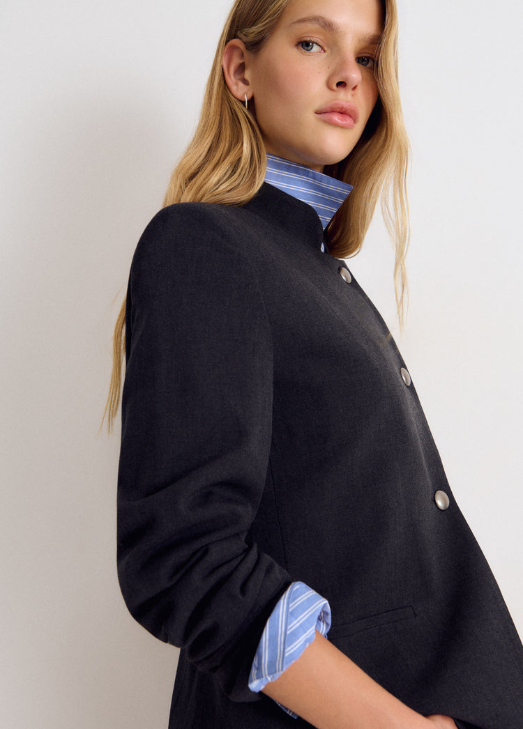 Chaqueta cruzada de color gris medio vista de perfil con botones metálicos y puños abotonados