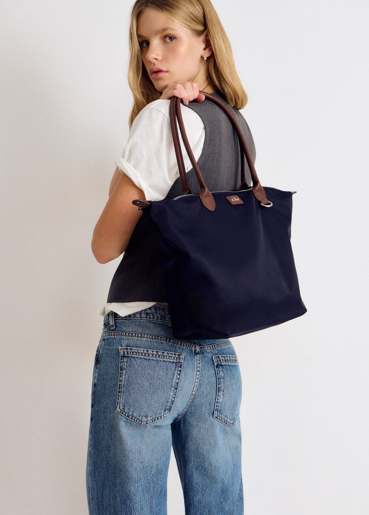 Bolso shopper de nylon azul marino con asas de piel visto de perfil