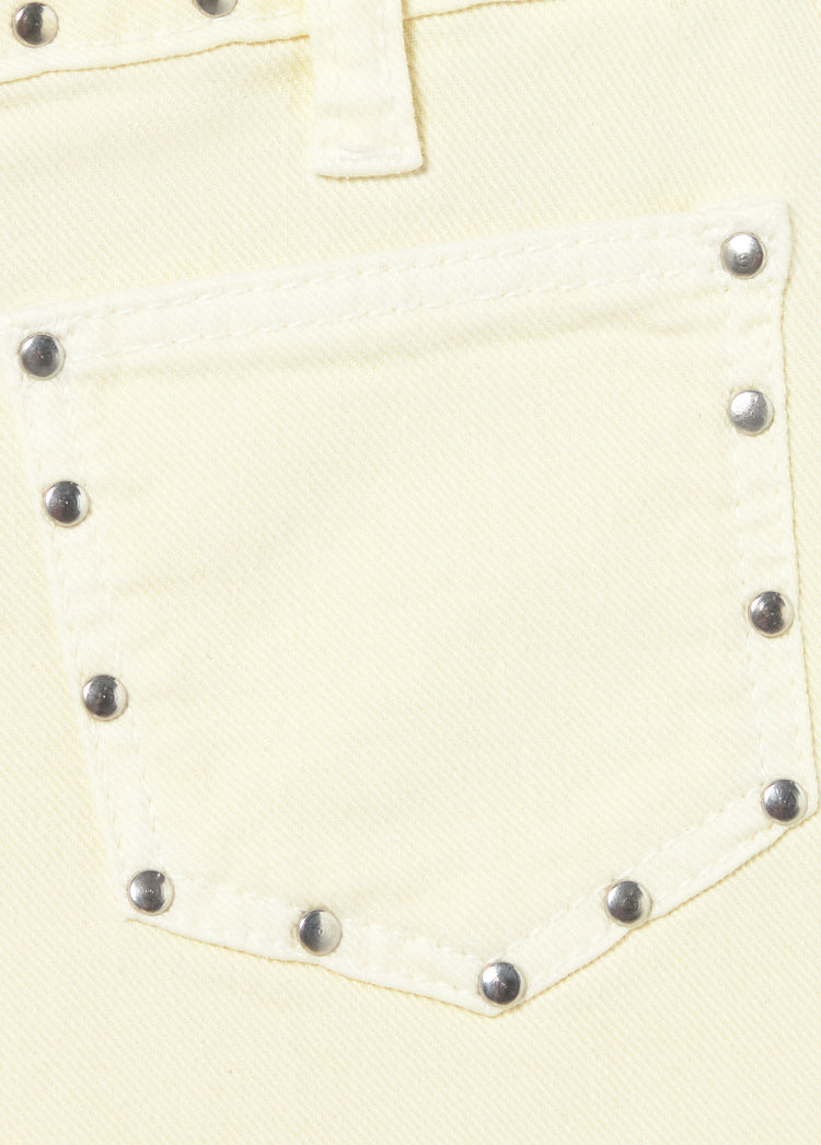 Short amarillo con tachas decorativas metálicas en el borde del bolsillo trasero