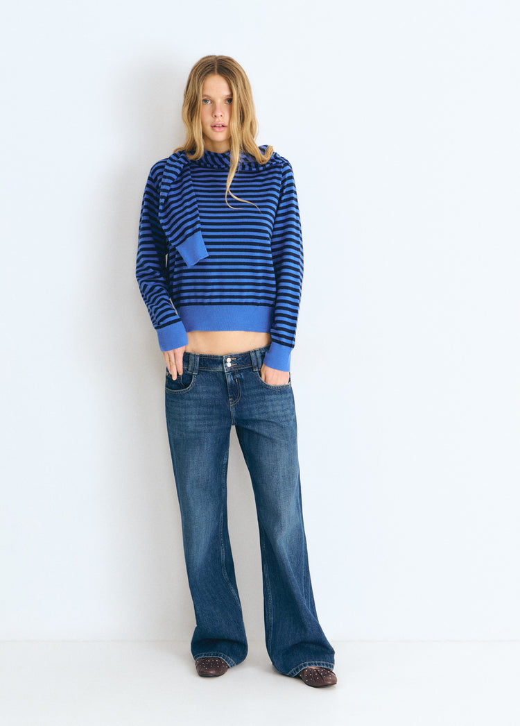 Jersey de rayas en azul con cuello abierto y corte corto lucido con vaqueros anchos