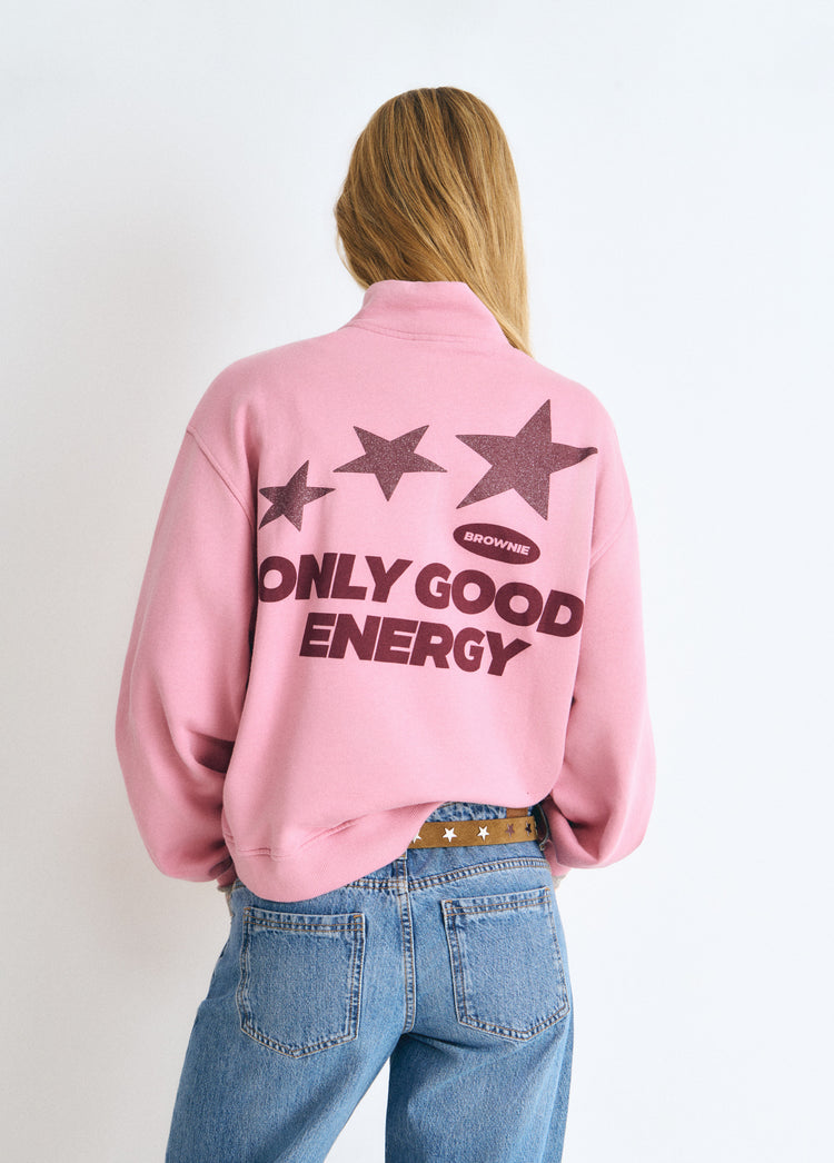Sudadera cremallera rosa vista por la espalda con estampado de estrellas y la frase "Only Good Energy