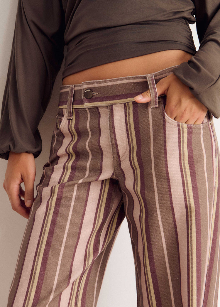 Pantalón vaquero de rayas verticales en tono rosa con detalle de botón metálico en la cintura