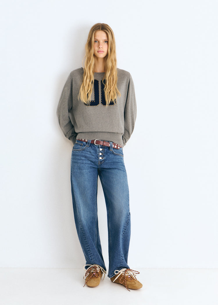 Pantalón vaquero barrel de color azul medio con corte amplio y botones frontales