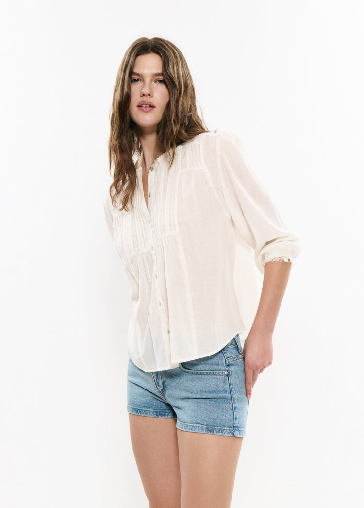 Blusa romántica plisada en tono blanco vista de perfil con mangas recogidas