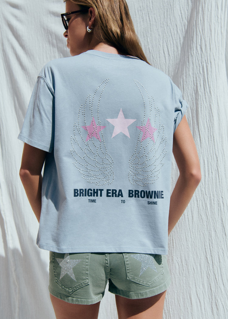 Camiseta de color azul claro con diseño de alas y estrellas en la espalda