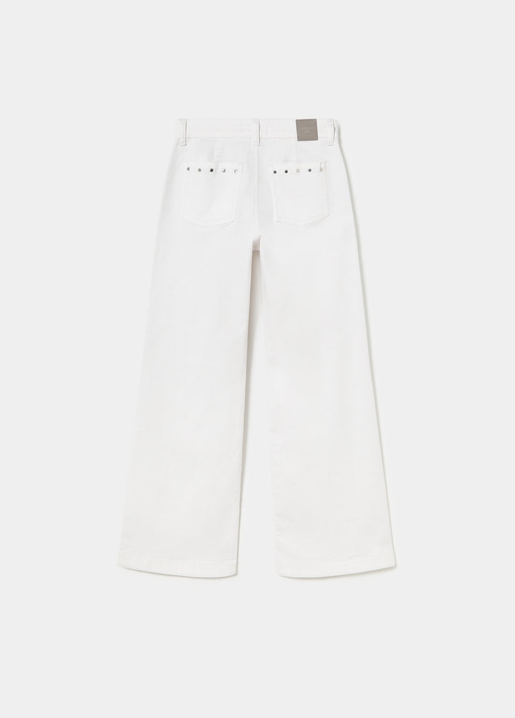 Pantalón culotte blanco con tachas metálicas en los bolsillos traseros visto desde atrás