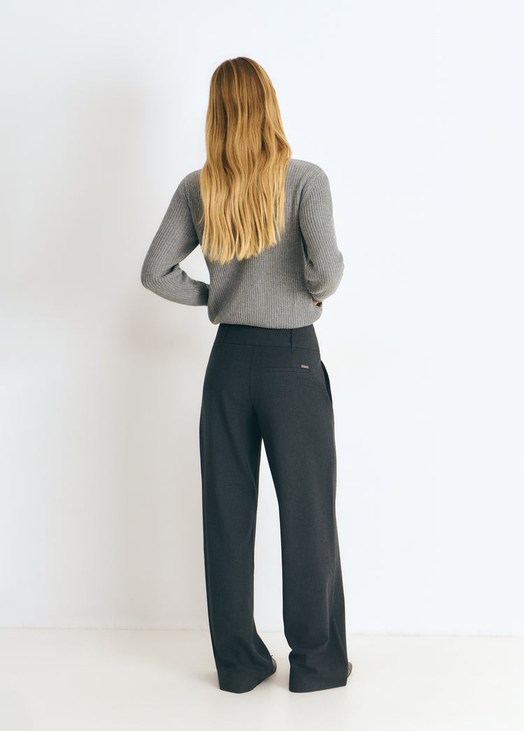 Pantalón de bajo cintura y pierna ancha en gris oscuro, visto por detrás