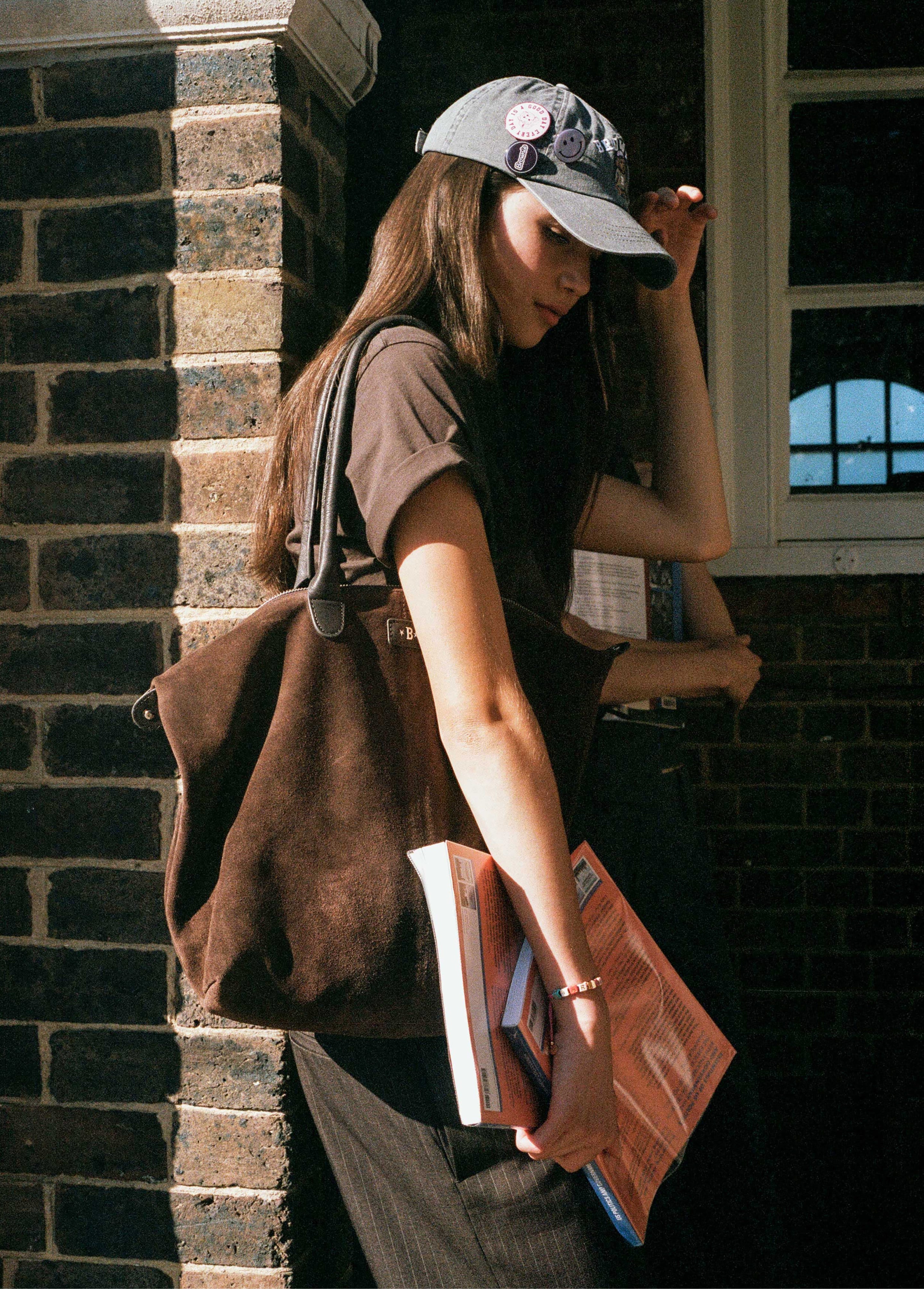 Bolso shopper de serraje color chocolate luciendo su perfil lateral con asas sobre el hombro