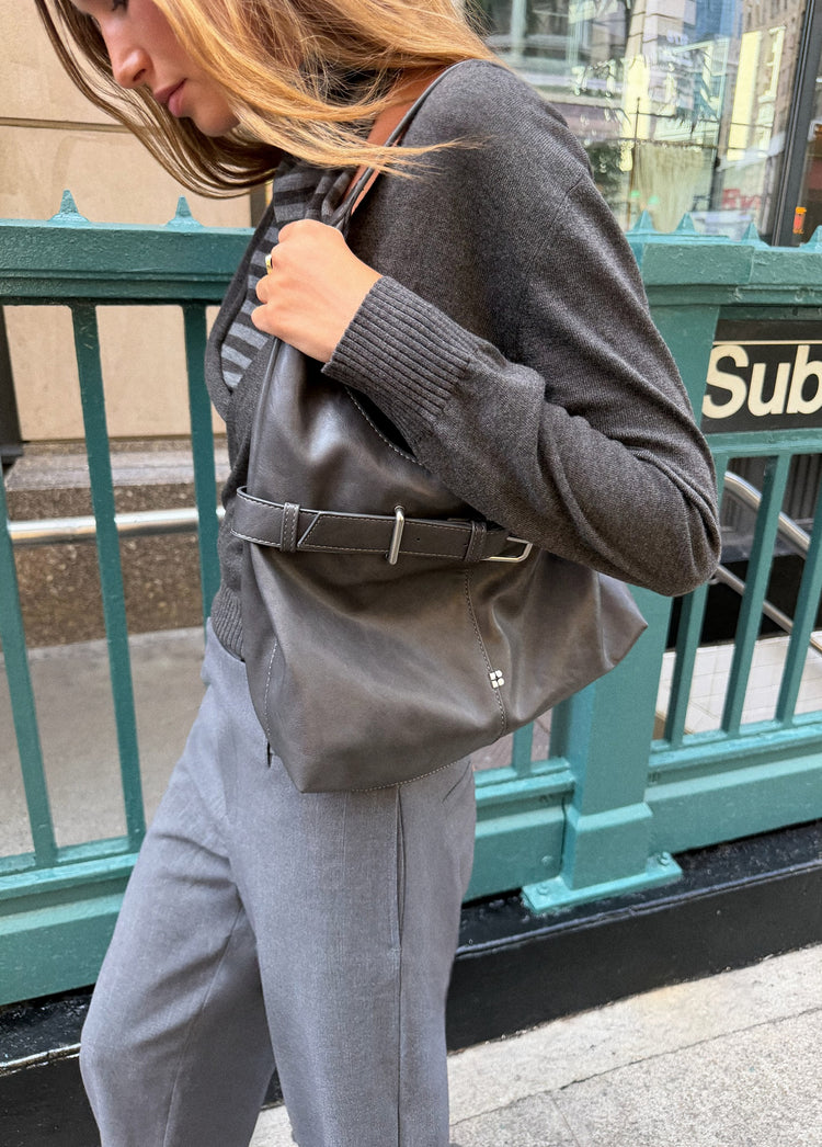 Pantalón gris de pierna ancha visto de perfil con el bolsillo lateral y la costura frontal