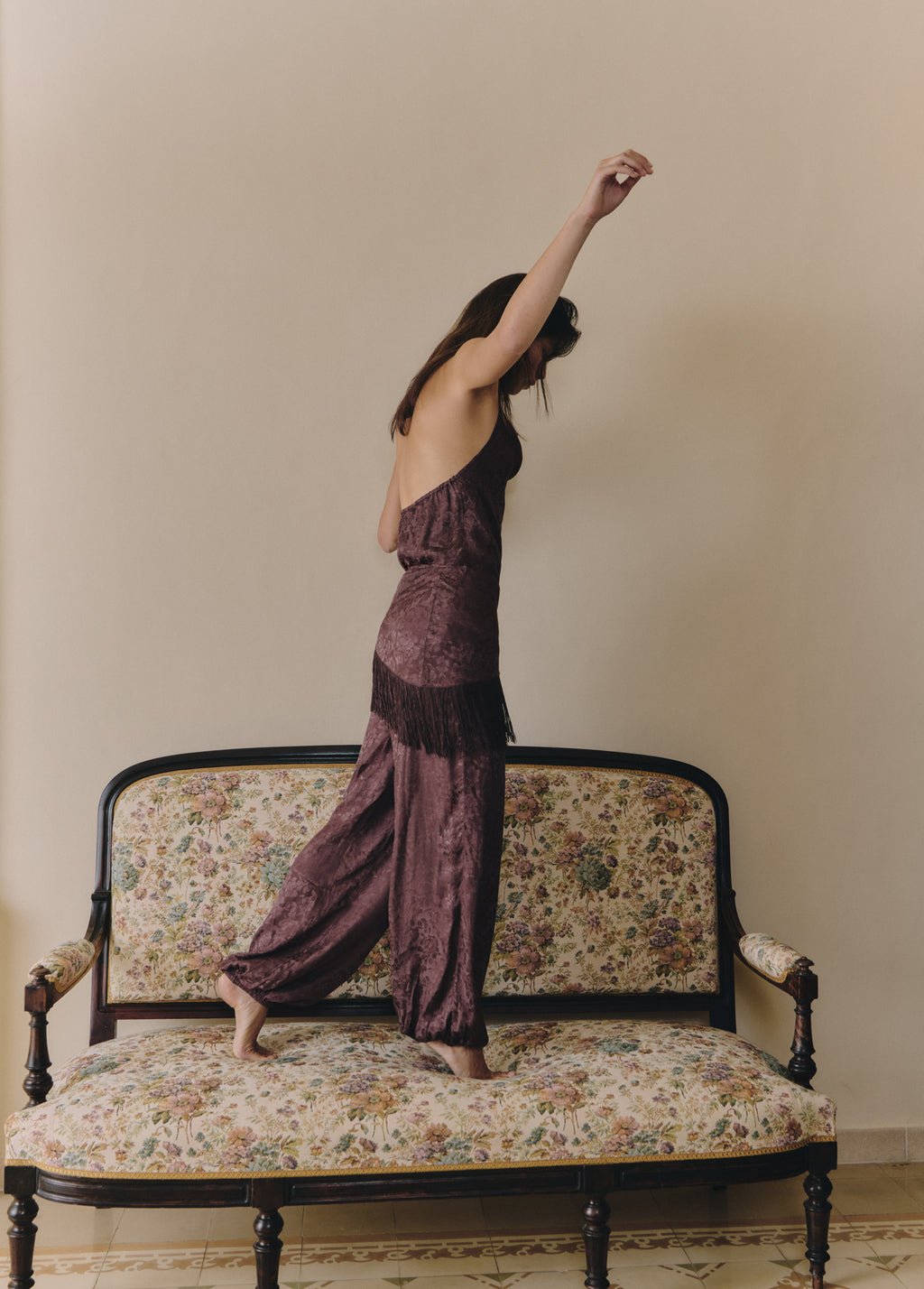Top halter de tejido jacquard en marrón, visto de perfil con el brazo extendido hacia arriba