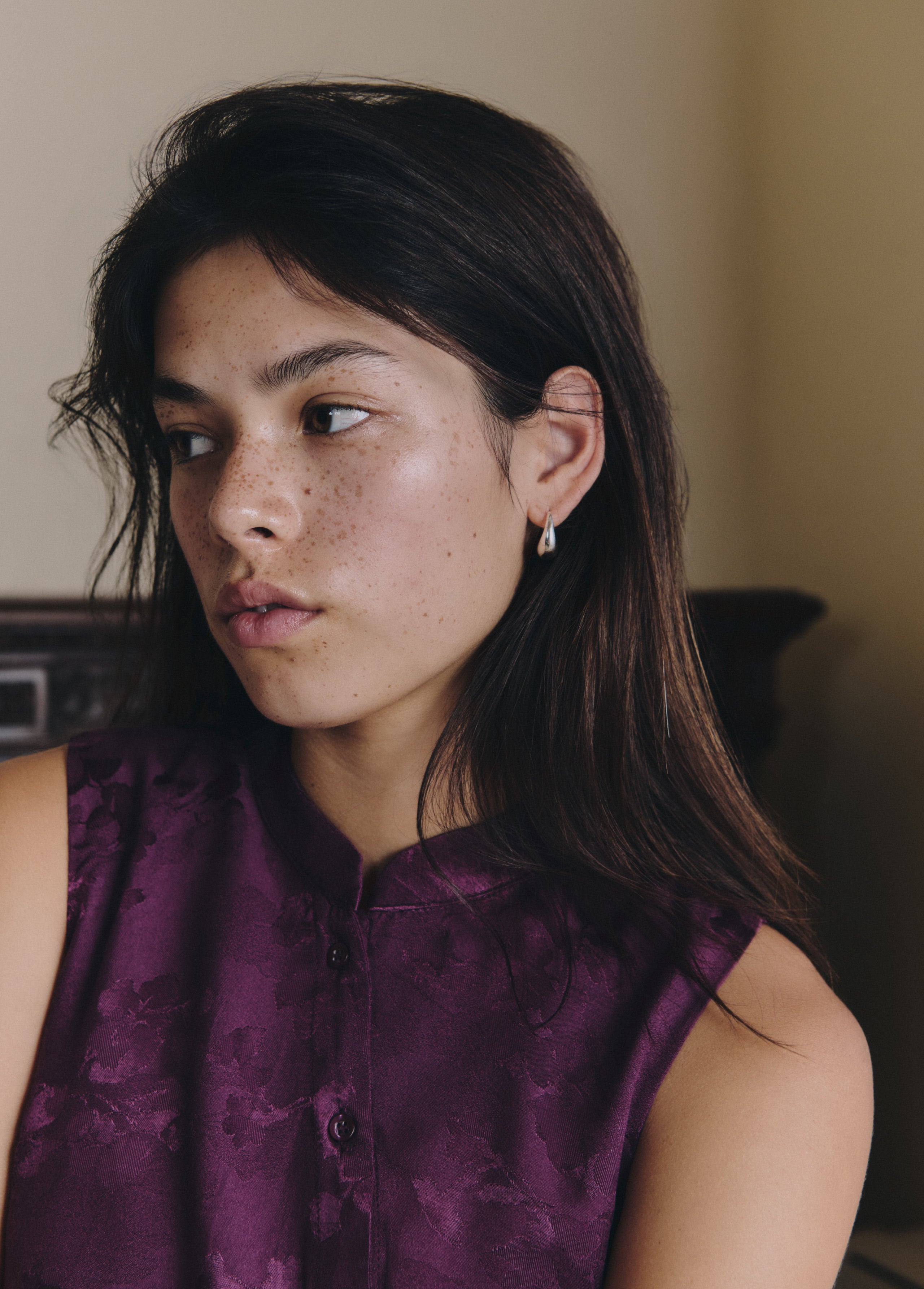Top lila de tejido jacquard sin mangas con botones, luciendo su textura y caída