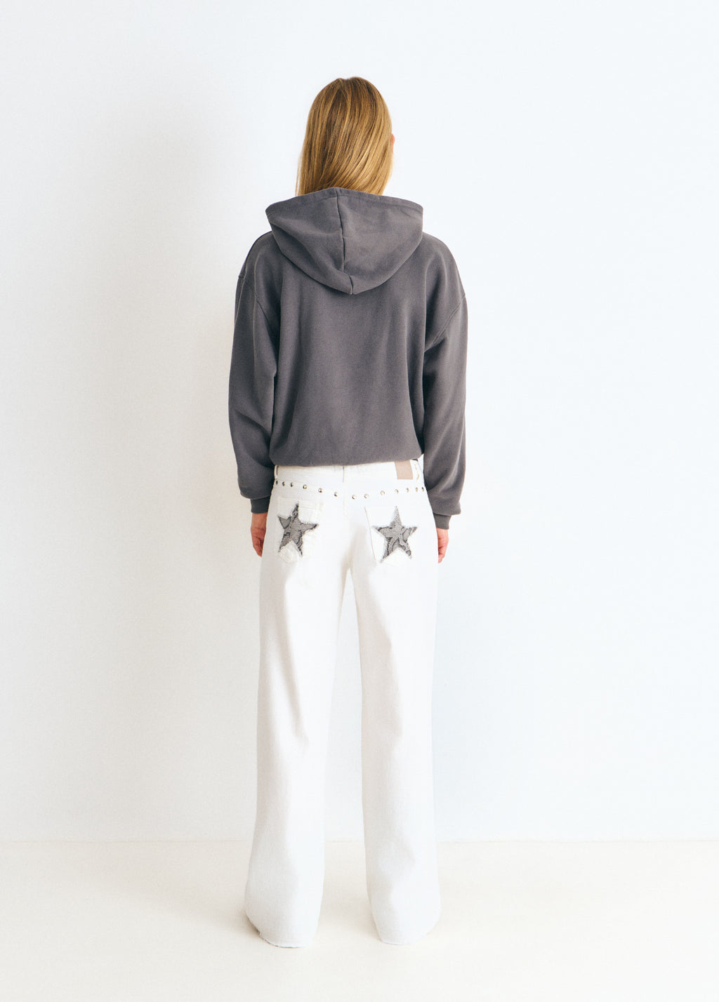 Pantalón blanco de tiro bajo con estrellas de brillo y tachas en los bolsillos traseros