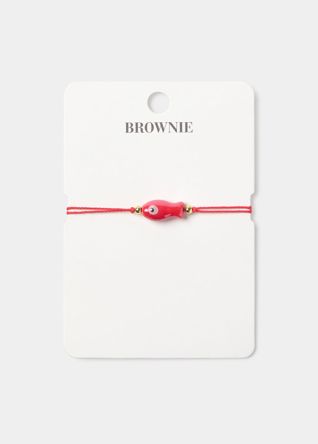 Pulsera de hilo rojo con un colgante de pez decorativo en tono rojo sobre su tarjeta de presentación