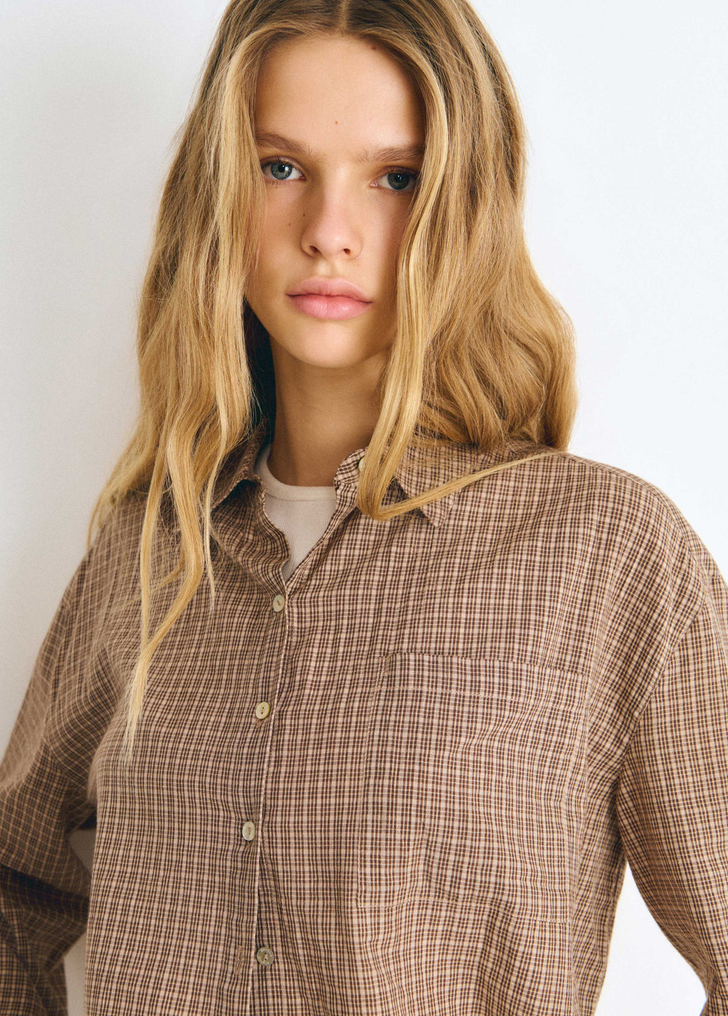 Blusa de cuadros en tono crudo con cuello abierto y botones frontales