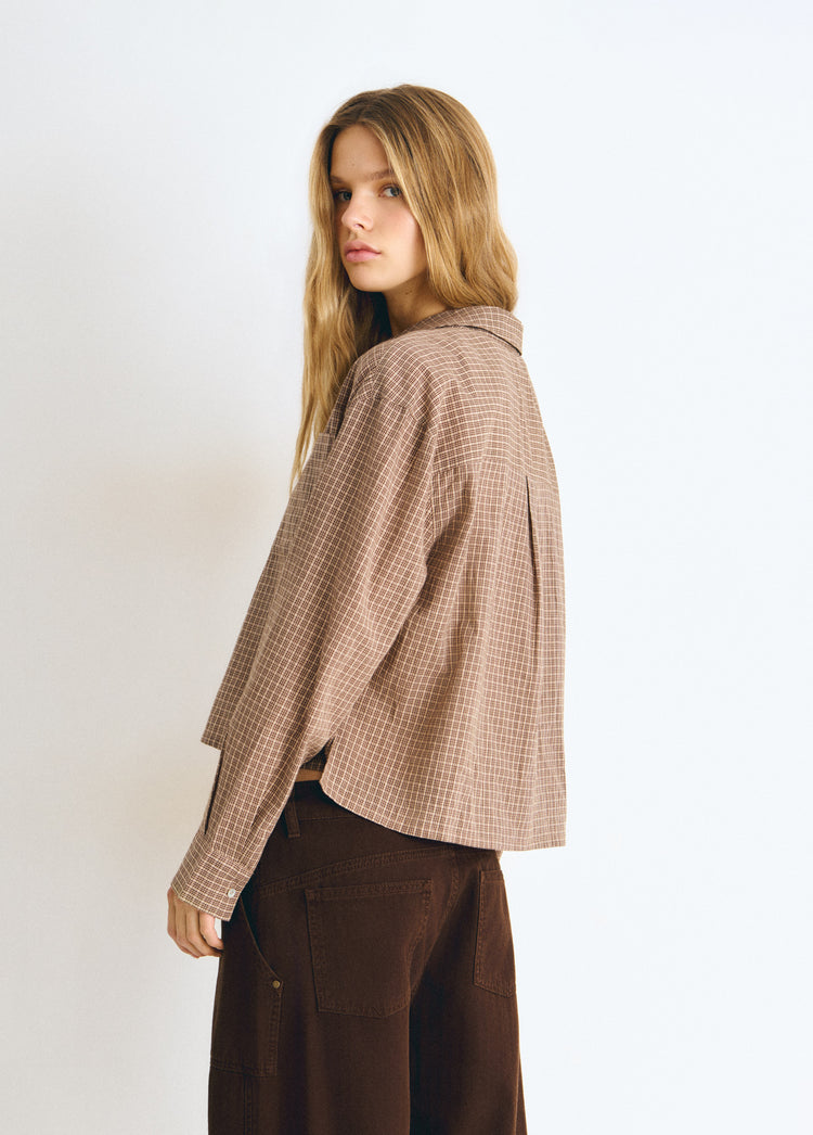 Blusa cropped de cuadros en tono crudo vista lateral con caída suelta y manga larga