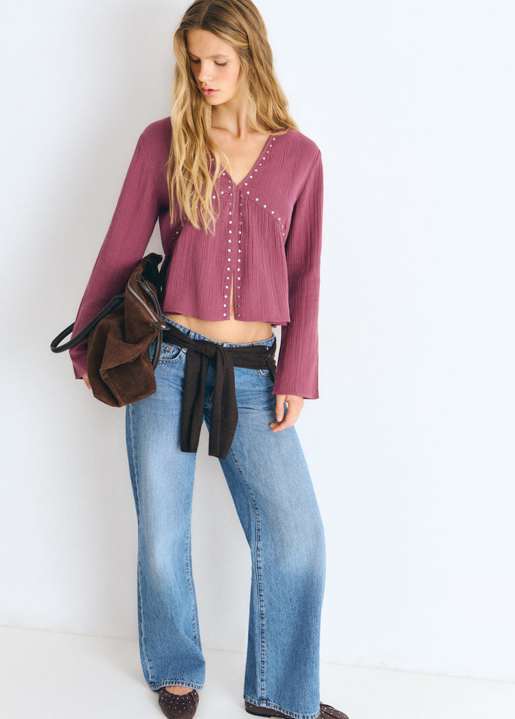 Blusa de manga larga en color rosado con escote en V y detalles de tachas