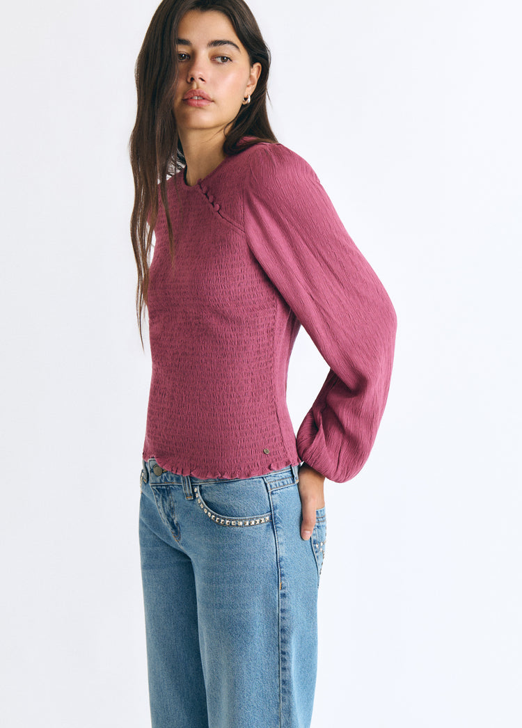 Blusa smock de manga larga en rosa luciendo su textura y caída sobre modelo