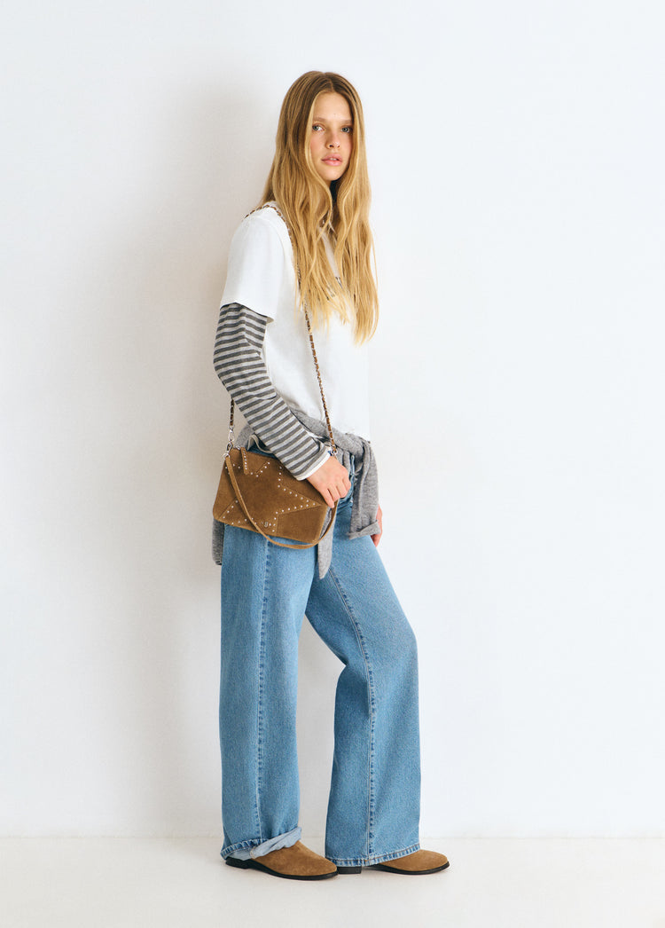 Bolso estrella de color taupe oscuro luciendo su perfil lateral con su correa metálica