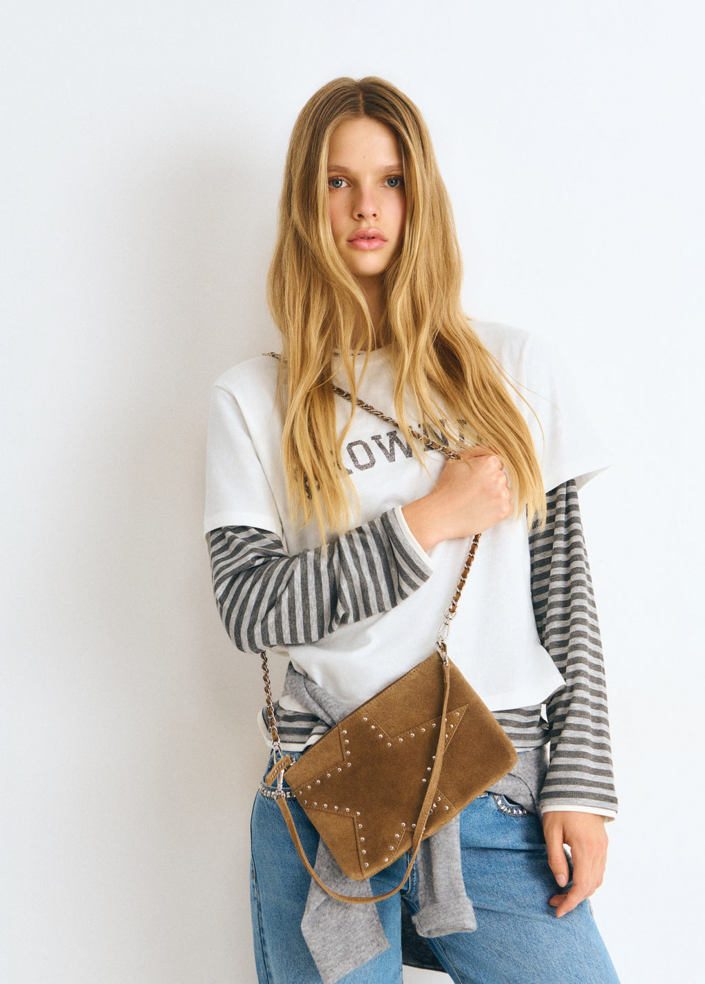 Bolso estrella de color taupe oscuro con tachitas colgado al hombro