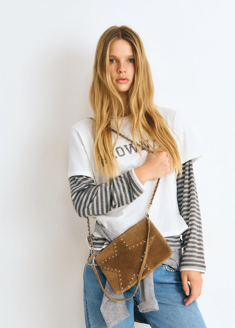 Bolso estrella de color taupe oscuro con tachitas colgado al hombro