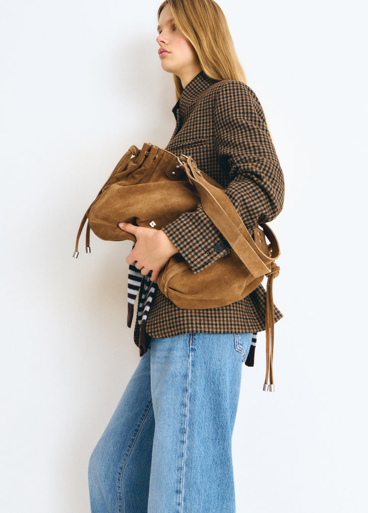 Bolso shopper fruncido de color camel luciendo su textura suave y detalles de cordones sobre modelo