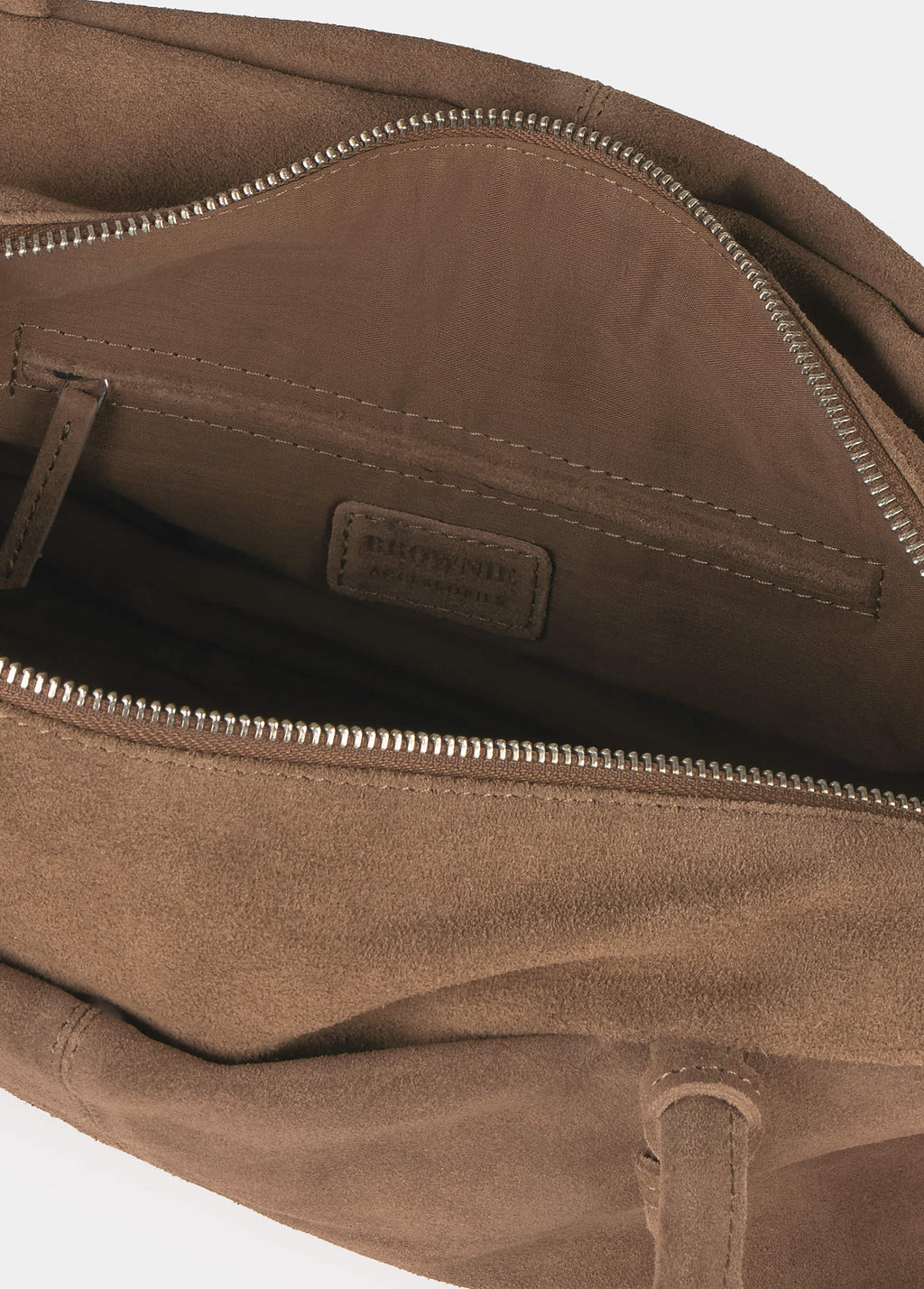 Interior del bolso baguette de ante en tono taupe con cremallera metálica y bolsillo interior