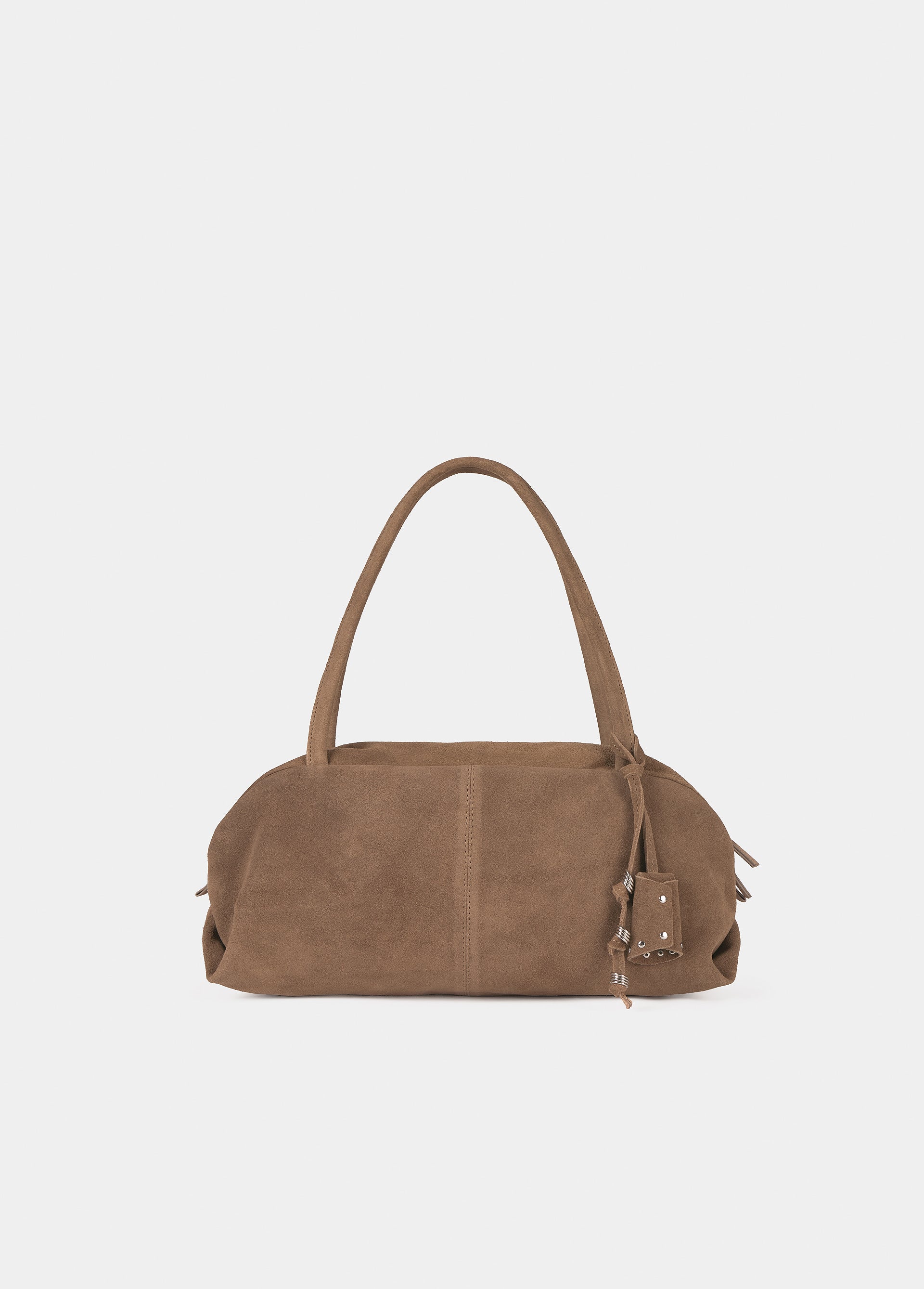 Bolso baguette de color taupe luciendo sus charms sobre modelo