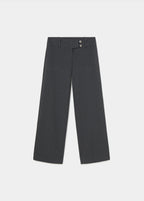 Pantalón de tiro bajo y pierna ancha en gris oscuro, visto de frente con las manos en los bolsillos