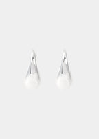 Aros pequeños de plata lucidos en el lóbulo de la oreja con un perfil elegante y minimalista