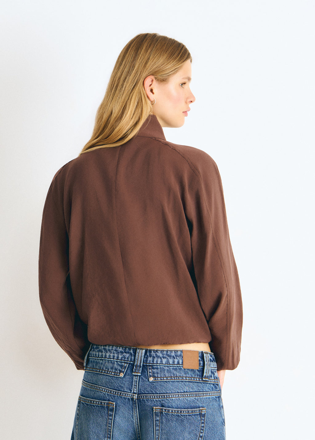 Blusa de manga larga y cuello alto en color marrón vista desde la espalda