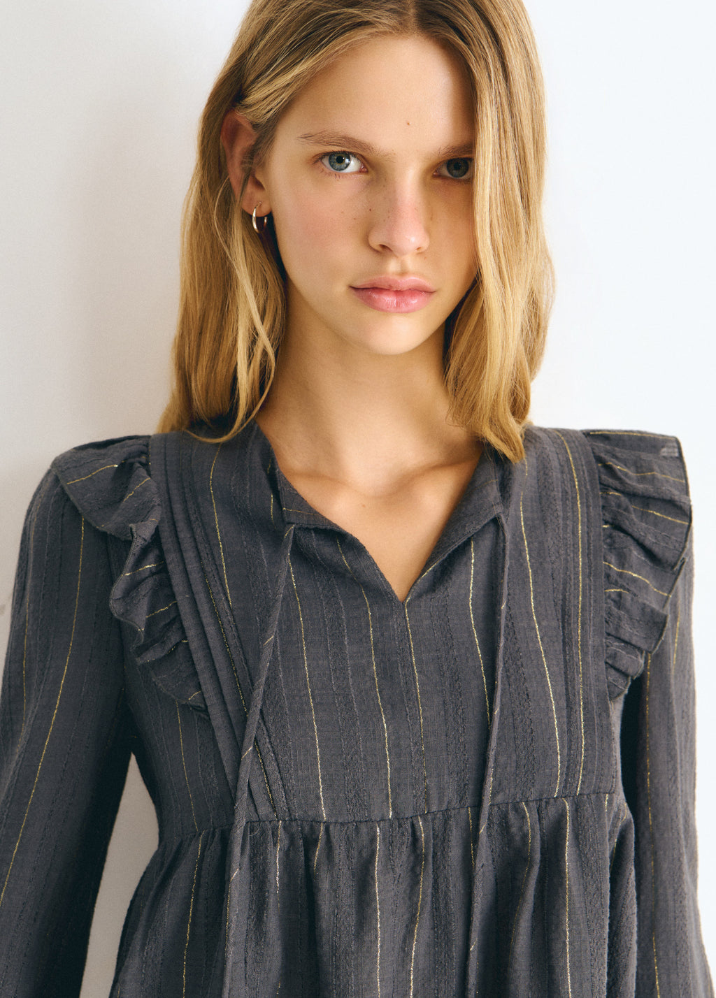 Blusa gris con volantes en los hombros y rayas lurex, vista frontal de la parte superior