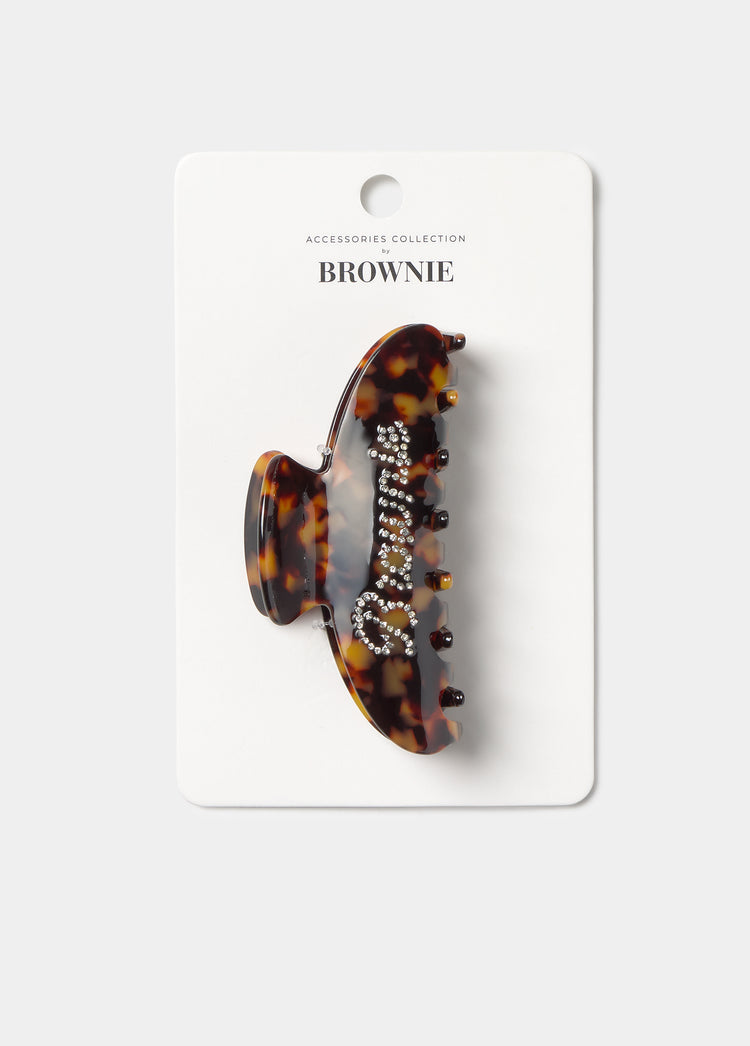 Pinza para el pelo de carey medio decorada con strass, presentada sobre su tarjeta de la colección de accesorios