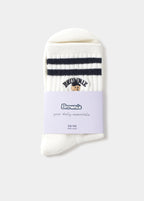 Calcetines crudos con estampado de perrito y texto, vistos en el pie con zapatillas de ante