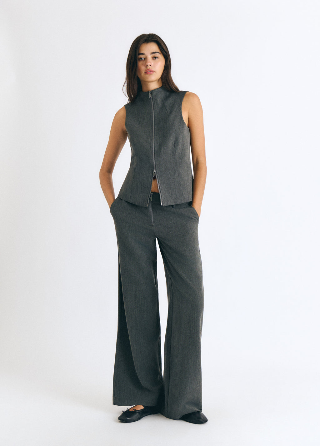 Top gris sin mangas con cremallera frontal vista completa sobre modelo