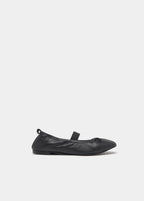 Bailarina de piel negra vista lateral con calcetines negros y jersey gris