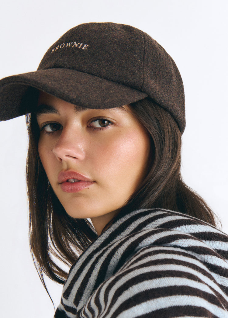Gorra de fieltro marrón con bordado frontal vista en primer plano sobre modelo