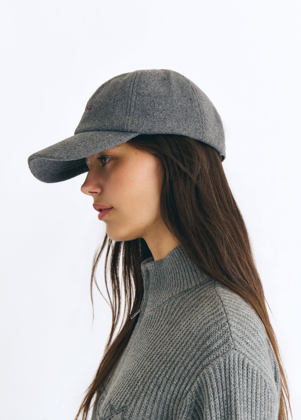 Gorra de fieltro gris vista de perfil sobre modelo con jersey de cuello alto