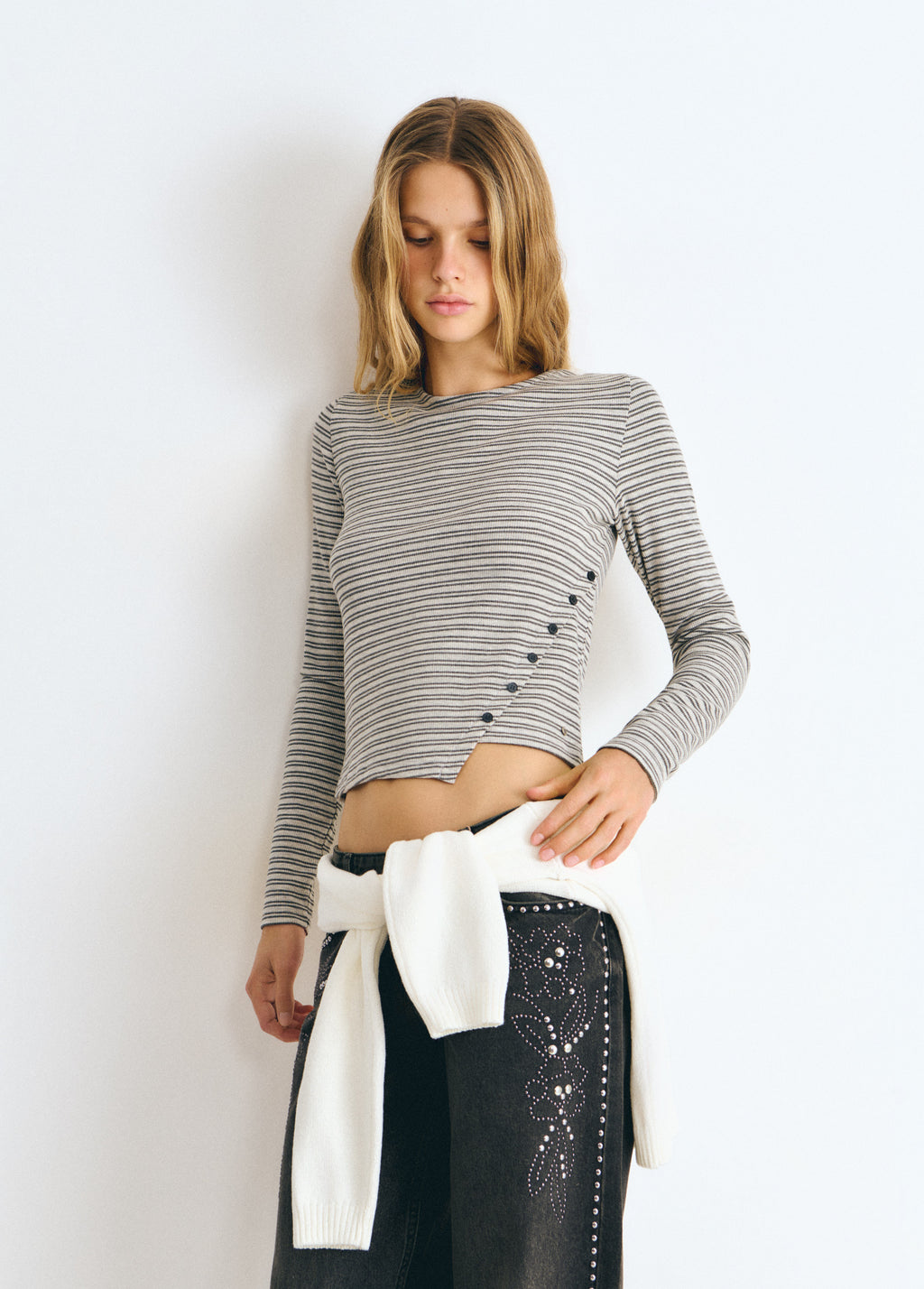 Camiseta de rayas finas en gris con botones laterales sobre modelo