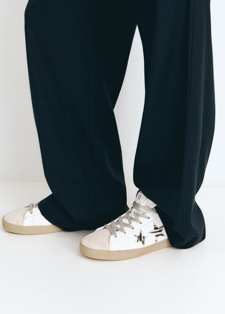 Zapatilla de lona con estampado animal print y brillo en tono crudo, vista en el pie