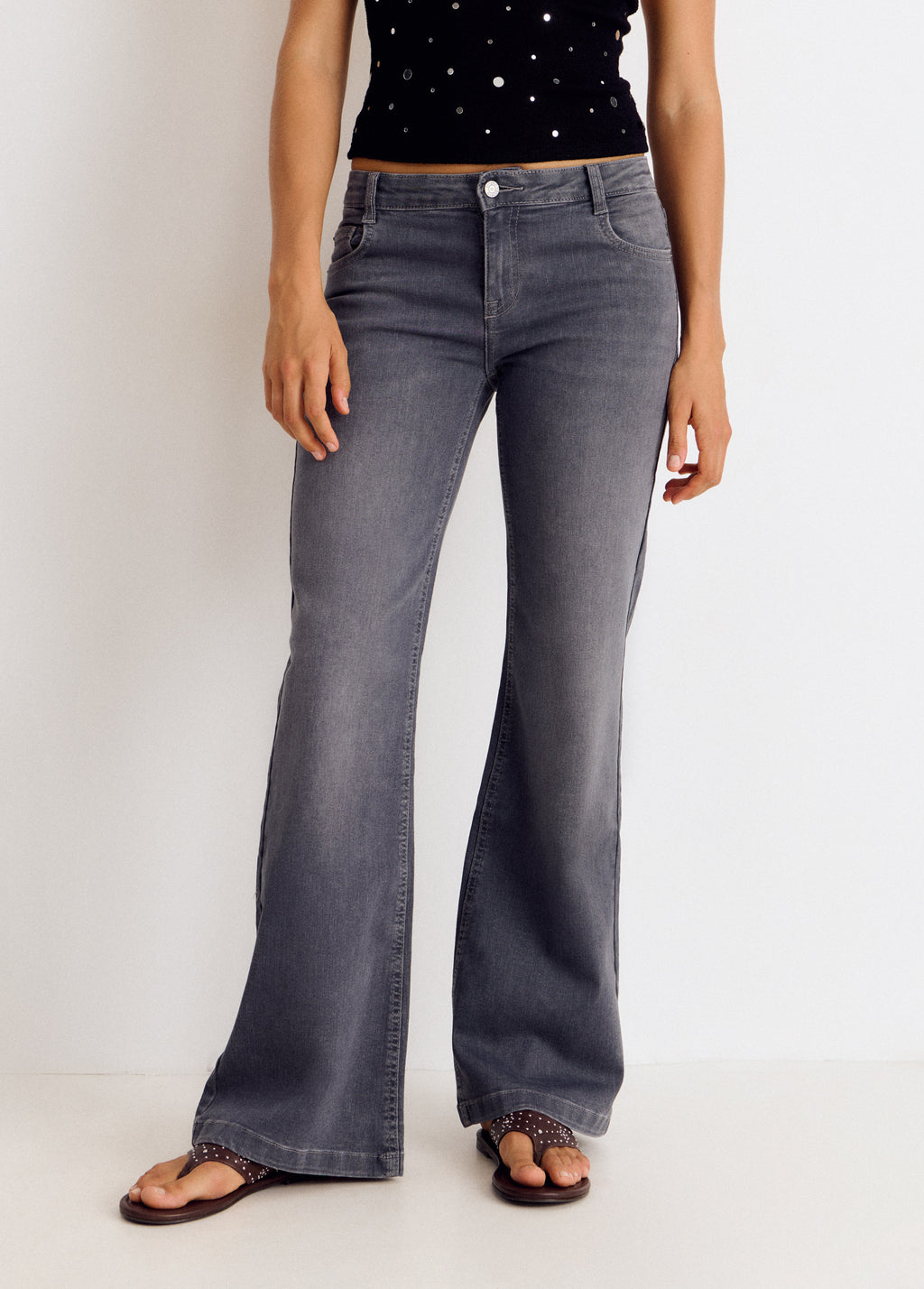 Vaqueros flare de color gris con bolsillos traseros vistos de frente