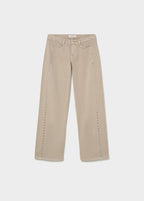 Pantalón recto de color arena con tachas decorativas sobre modelo