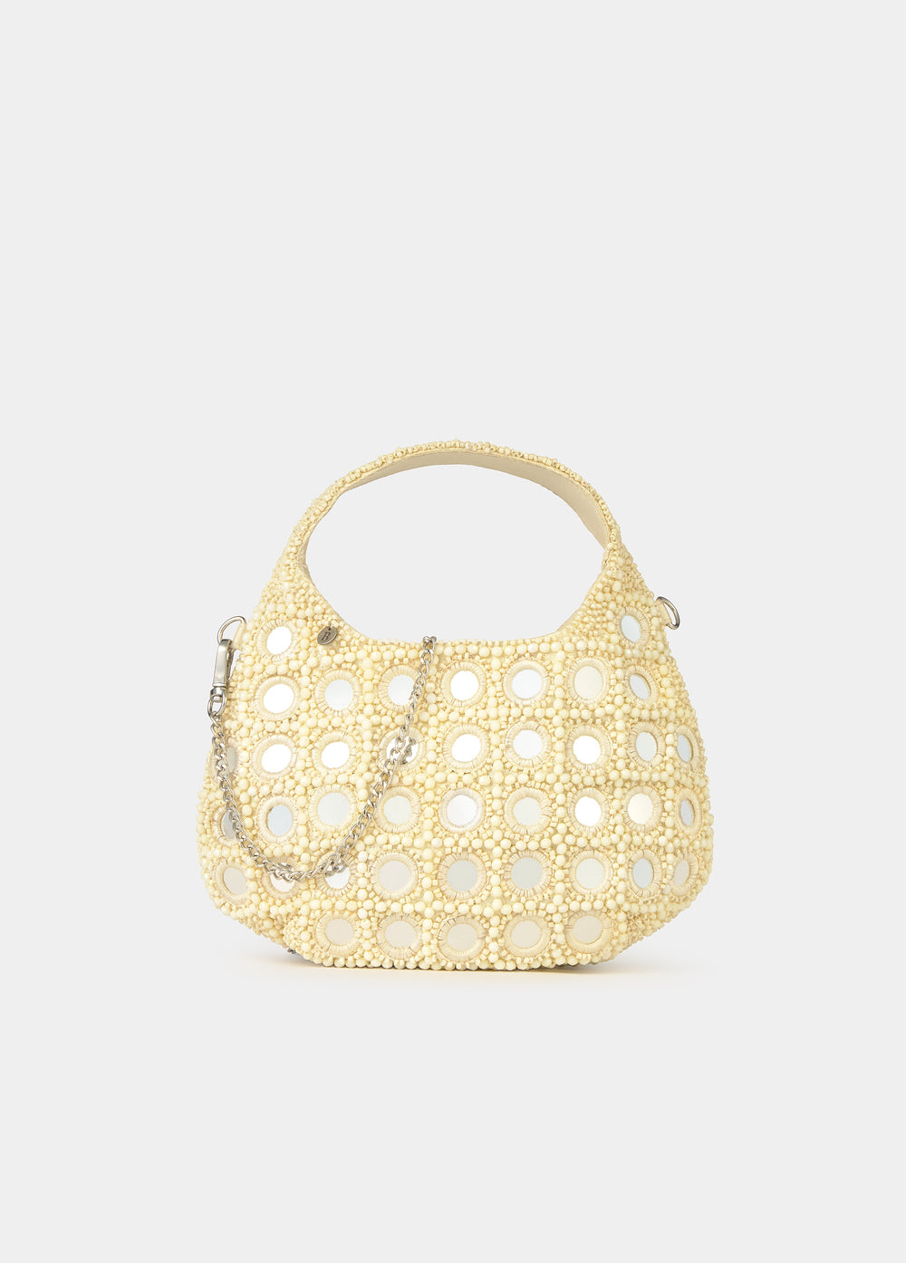 Bolso pequeño de crochet en tono crudo con apliques de espejos redondos luciendo su forma semicircular
