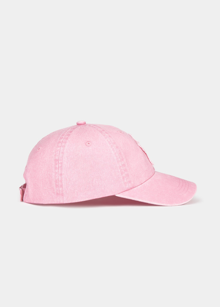 Gorra de béisbol rosa vista de perfil con visera curva y parche lateral