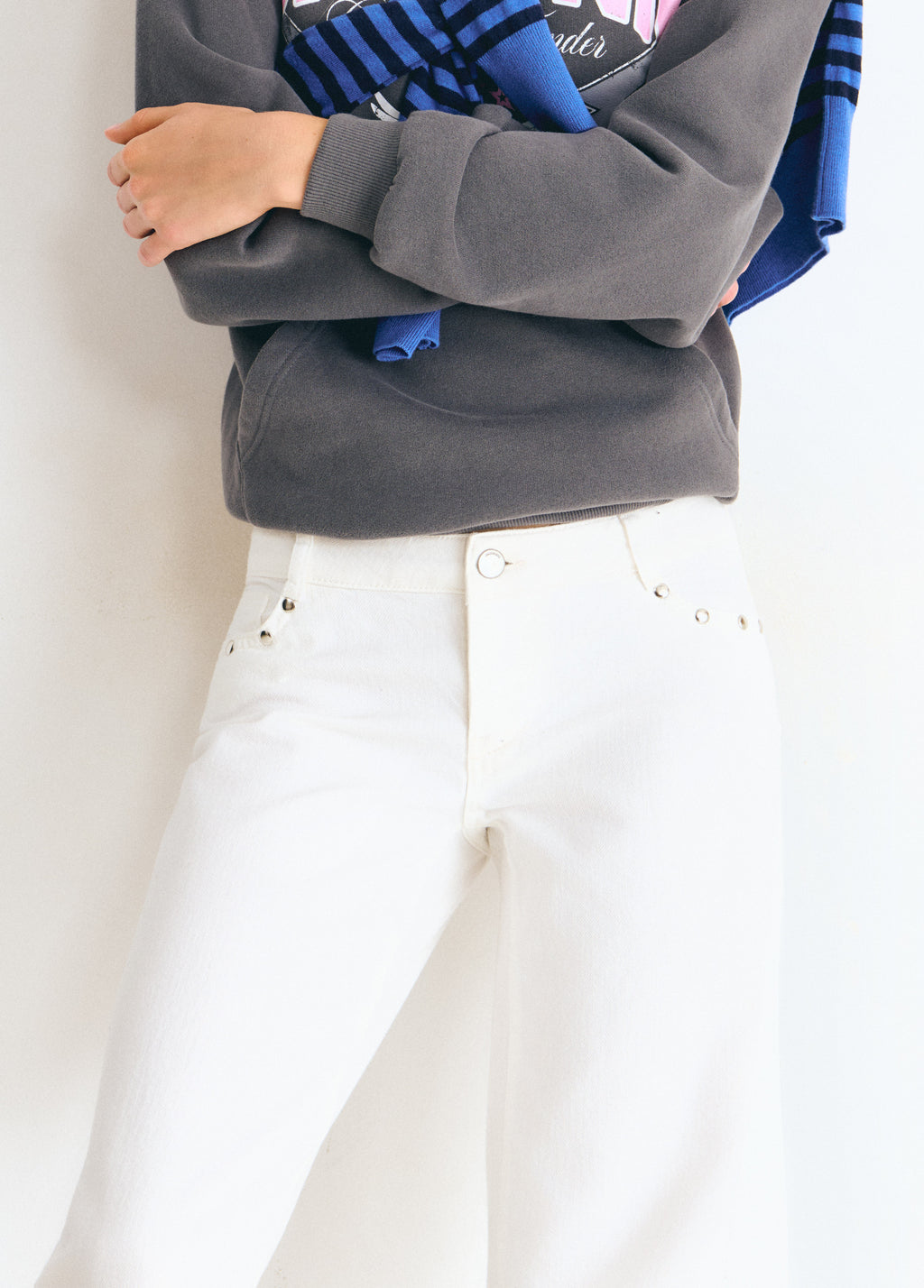 Pantalón blanco de tiro bajo con tachas metálicas en la parte superior