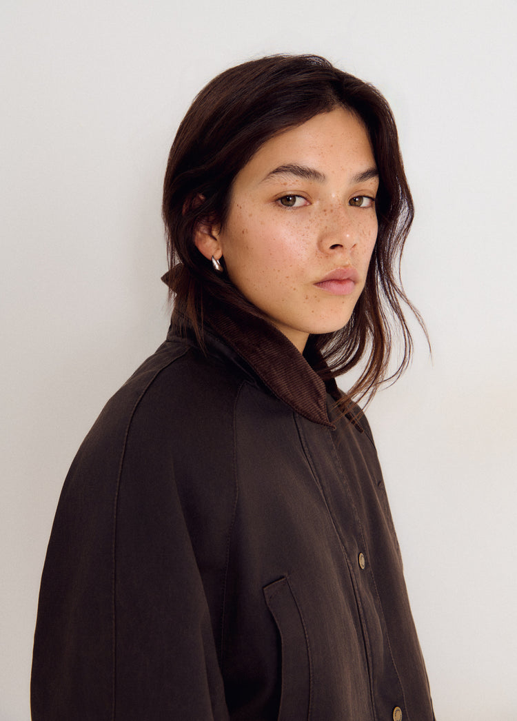 Chaqueta encerada marrón vista de perfil con el cuello de borrego y los botones frontales